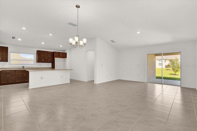 unfurnished living room featuring an inviting chandelier, a healthy amount of sunlight, light tile patterned flooring, and sink