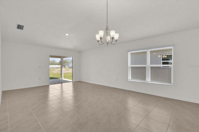 spare room with a chandelier and light tile patterned floors