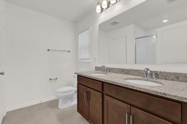 bathroom with vanity, toilet, tile patterned floors, and walk in shower