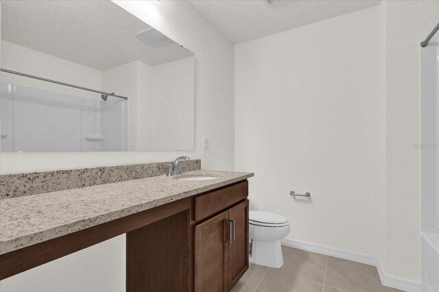 full bathroom featuring toilet, vanity,  shower combination, and tile patterned flooring