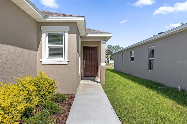 view of exterior entry featuring a yard