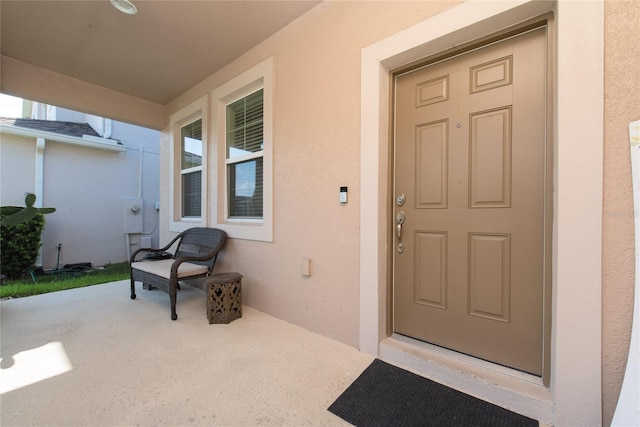 view of exterior entry featuring covered porch