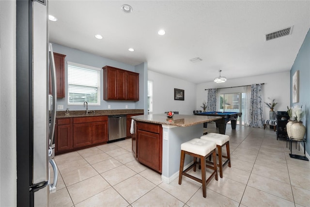 kitchen featuring sink, a center island, stainless steel appliances, a kitchen breakfast bar, and pool table