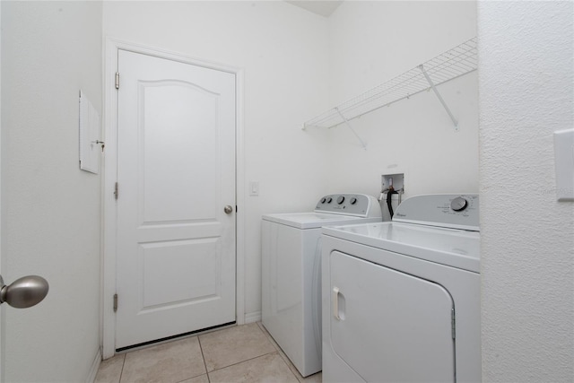 laundry room featuring washing machine and dryer and light tile patterned flooring