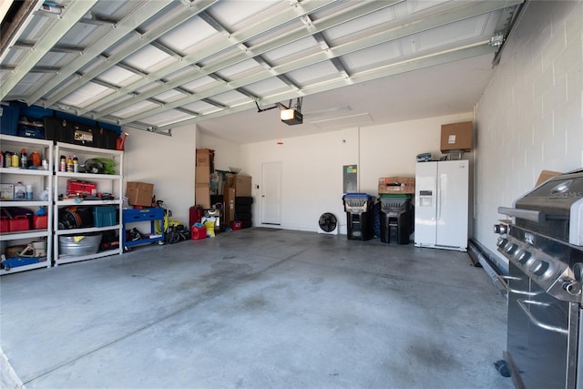 garage with a garage door opener, white fridge with ice dispenser, and electric panel