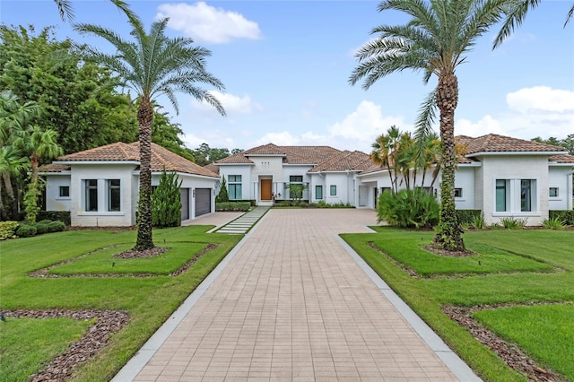 mediterranean / spanish house with a garage and a front yard