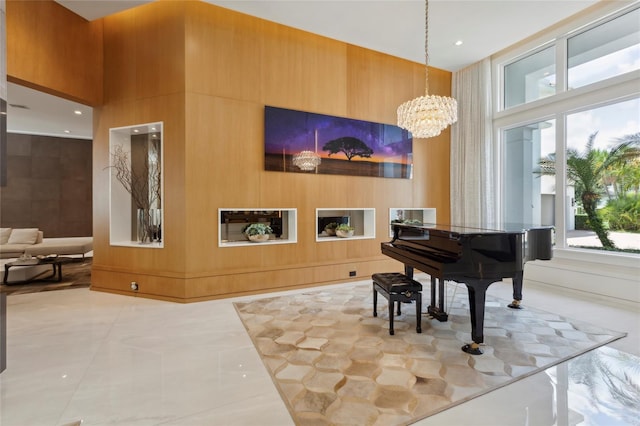 misc room with a towering ceiling, an inviting chandelier, and light tile patterned floors