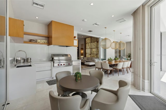 interior space featuring sink, light tile patterned flooring, and a healthy amount of sunlight