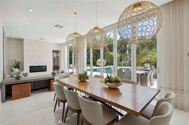 dining room with light tile patterned flooring and a fireplace