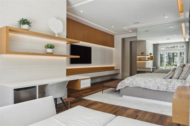 bedroom with dark hardwood / wood-style flooring, refrigerator, crown molding, and built in desk