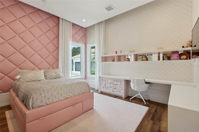 bedroom featuring hardwood / wood-style floors and built in desk