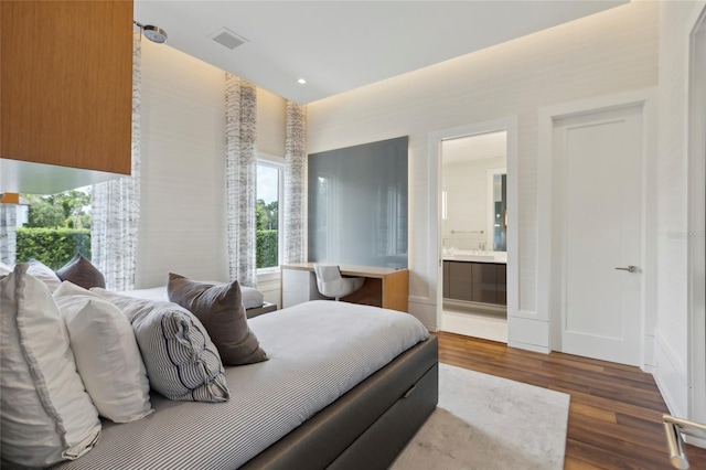 bedroom with dark hardwood / wood-style floors and ensuite bathroom