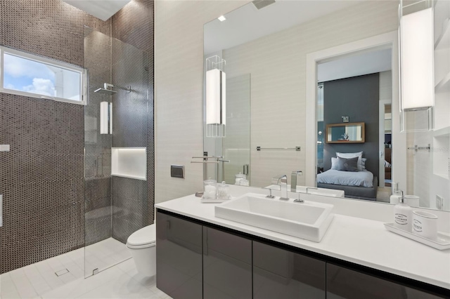 bathroom with toilet, vanity, and a shower with shower door