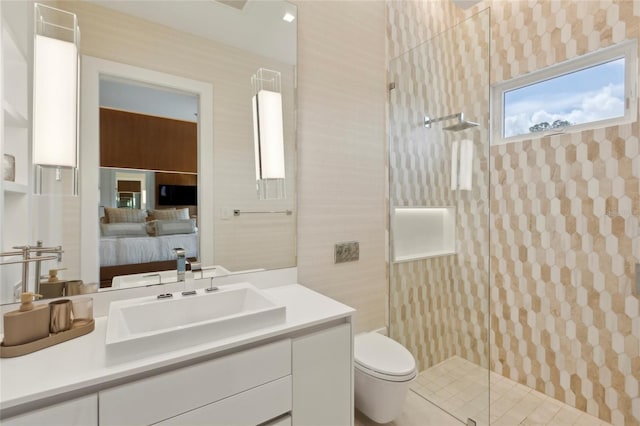 bathroom featuring a shower with door, toilet, and vanity