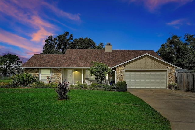 ranch-style house with a garage and a yard