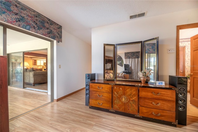 bedroom with light wood-type flooring and a textured ceiling