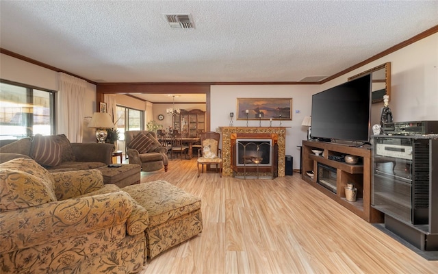 living room with a chandelier, hardwood / wood-style floors, a textured ceiling, and crown molding