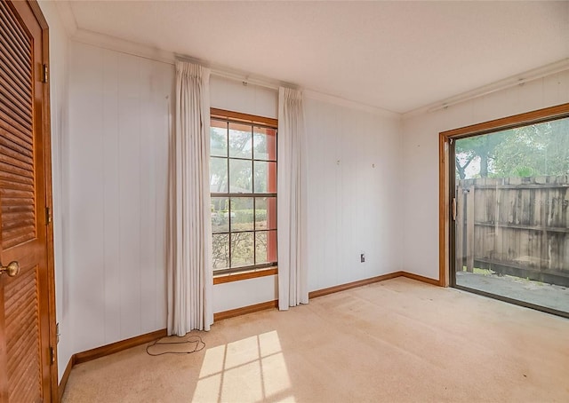 unfurnished room featuring a healthy amount of sunlight, light carpet, and ornamental molding