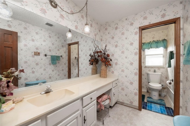 bathroom featuring toilet, vanity, and a textured ceiling