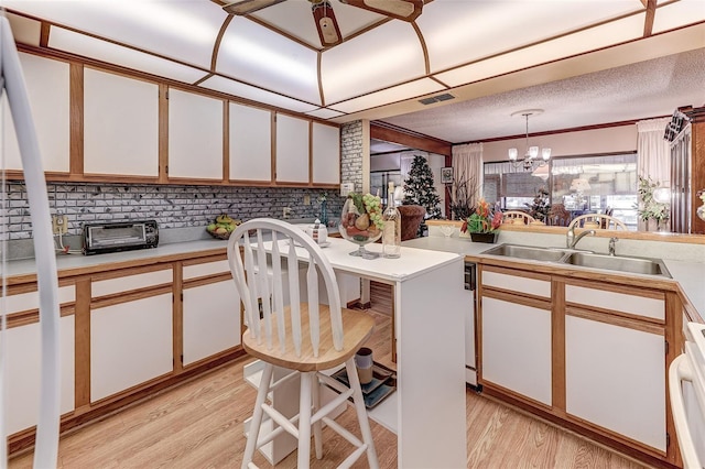 1546 Stormway Ct, Apopka, FL 32712 - kitchen with a sink, light countertops, light wood-style flooring, a chandelier, and white cabinetry