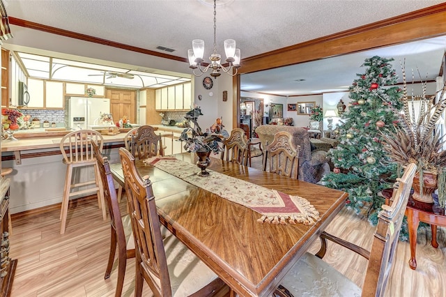 1546 Stormway Ct, Apopka, FL 32712 - dining space with crown molding, a textured ceiling, a chandelier, and light wood-type flooring