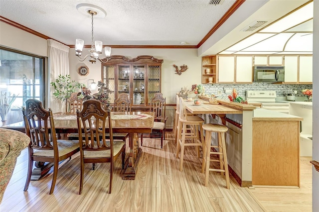 1546 Stormway Ct, Apopka, FL 32712 - dining area with a chandelier, ornamental molding, a textured ceiling, and light wood finished floors