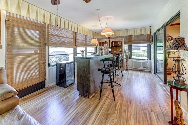 1546 Stormway Ct, Apopka, FL 32712 - kitchen featuring light wood finished floors, cooling unit, a kitchen bar, a center island, and hanging light fixtures