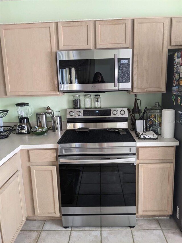 kitchen featuring light brown cabinetry, light tile patterned floors, and appliances with stainless steel finishes