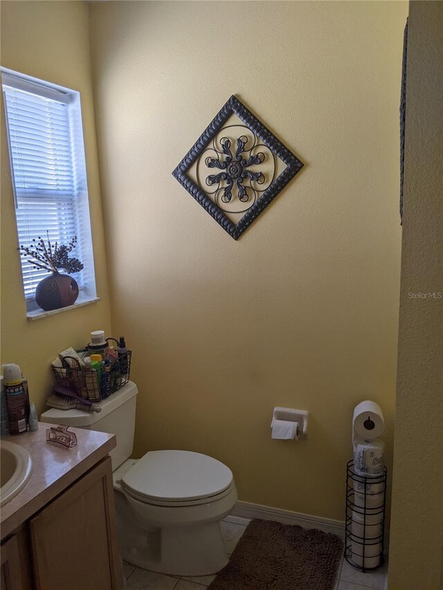 bathroom featuring tile patterned flooring, vanity, and toilet