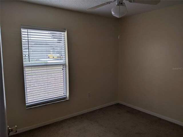 empty room featuring a textured ceiling, carpet flooring, and ceiling fan