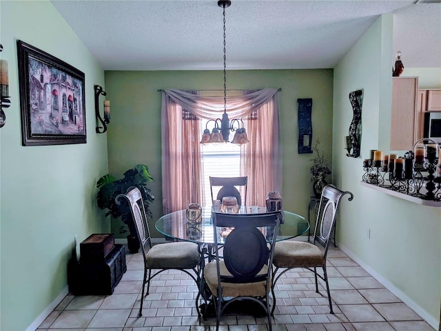 dining area featuring a textured ceiling, light tile patterned flooring, and a notable chandelier