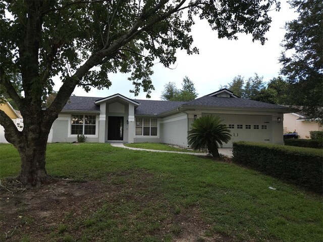 single story home featuring a garage and a front lawn