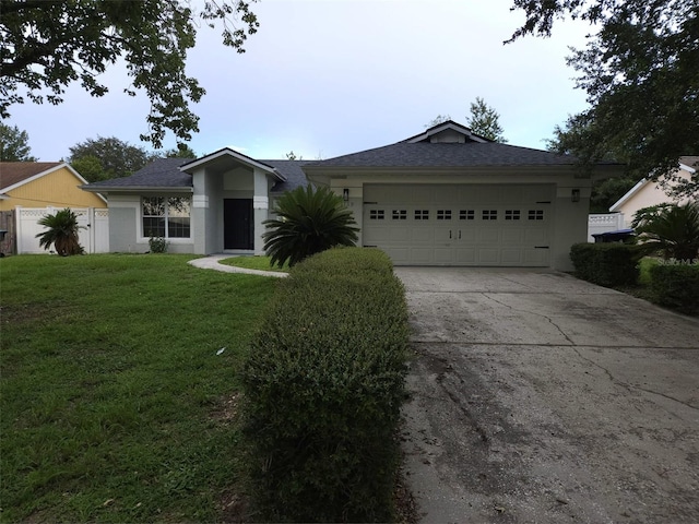 ranch-style house featuring a garage and a front yard