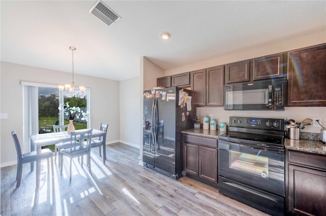 kitchen featuring stone countertops, light hardwood / wood-style floors, an inviting chandelier, and black appliances