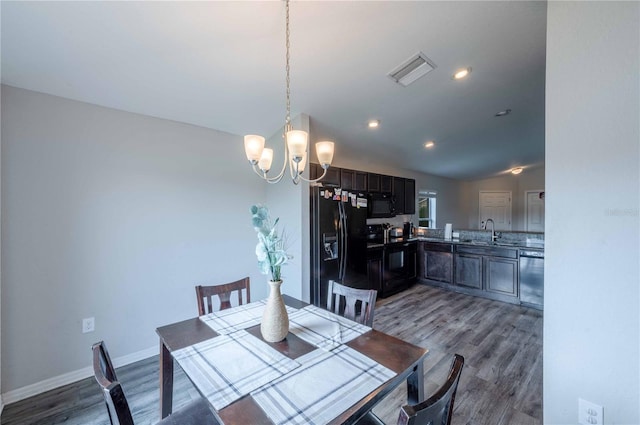 dining room featuring baseboards, visible vents, an inviting chandelier, and wood finished floors