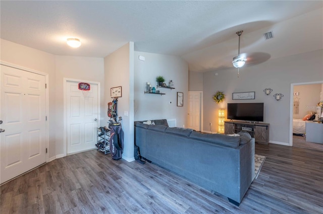 living room with ceiling fan, vaulted ceiling, and hardwood / wood-style flooring