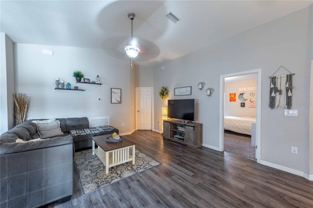 living room featuring visible vents, a ceiling fan, vaulted ceiling, baseboards, and dark wood-style floors