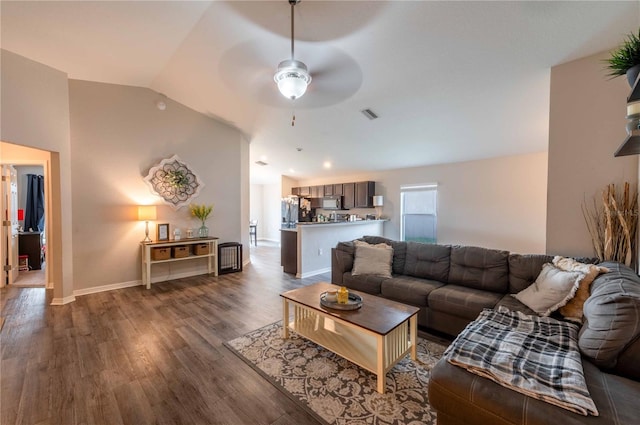 living room with baseboards, visible vents, ceiling fan, wood finished floors, and vaulted ceiling