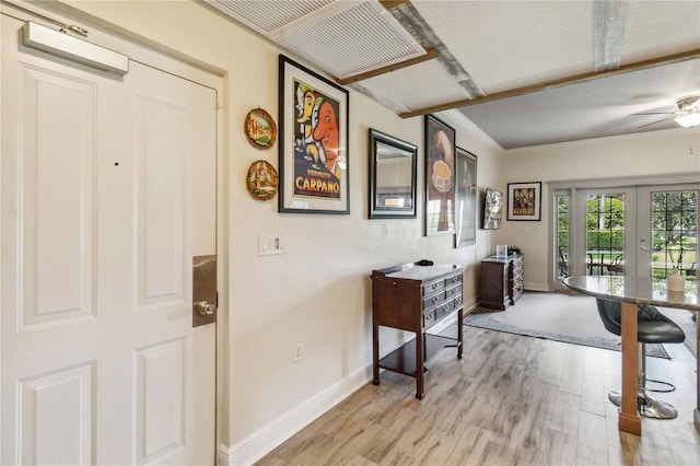 interior space featuring a textured ceiling, light hardwood / wood-style flooring, and french doors