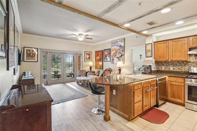 kitchen with appliances with stainless steel finishes, tasteful backsplash, sink, a textured ceiling, and ceiling fan