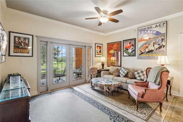 sitting room with ceiling fan, a textured ceiling, french doors, and ornamental molding