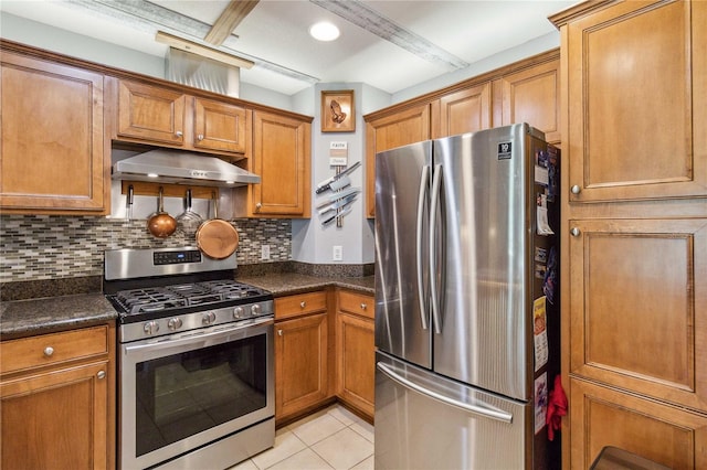 kitchen featuring light tile patterned floors, stainless steel appliances, dark stone counters, and tasteful backsplash