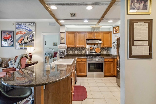 kitchen with tasteful backsplash, a breakfast bar, light tile patterned floors, sink, and stainless steel appliances