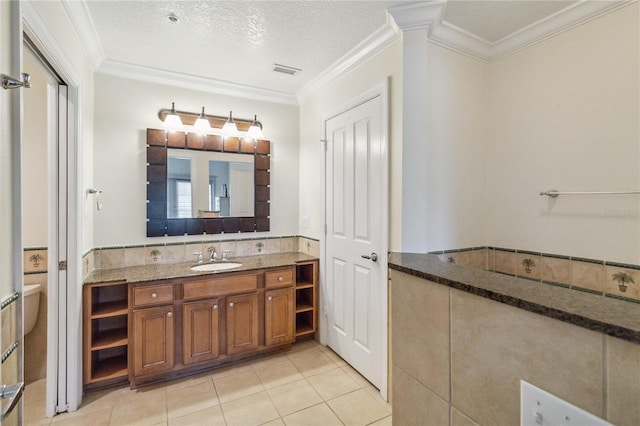 bathroom featuring a textured ceiling, tile patterned flooring, ornamental molding, and vanity