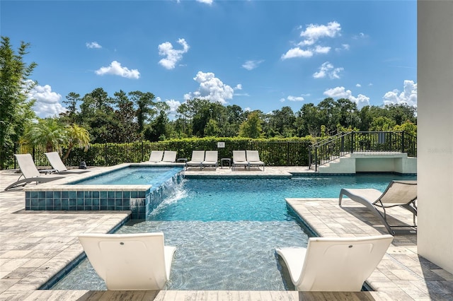 view of swimming pool with pool water feature, an in ground hot tub, and a patio area