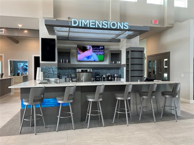 bar with light tile patterned flooring and decorative backsplash