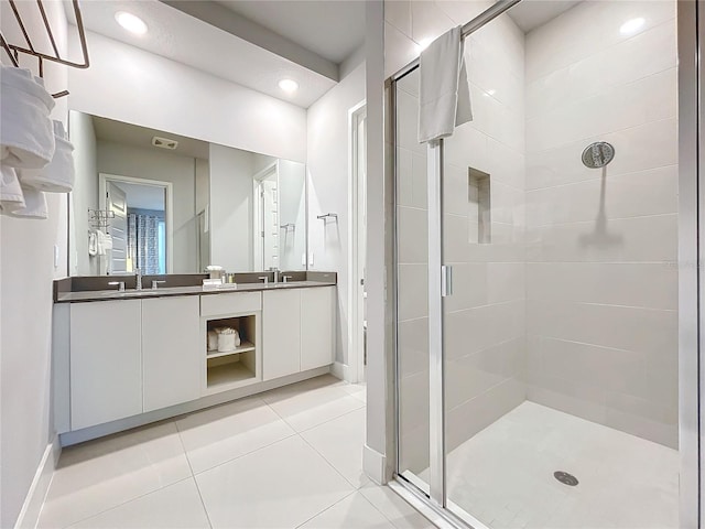 bathroom with double vanity, recessed lighting, a stall shower, a sink, and tile patterned floors