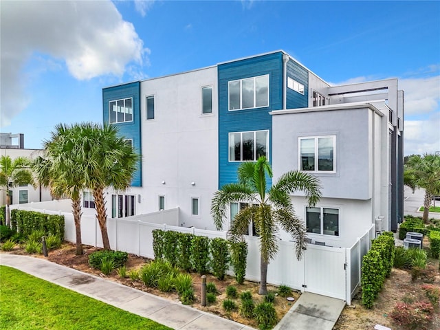 modern home featuring fence and stucco siding