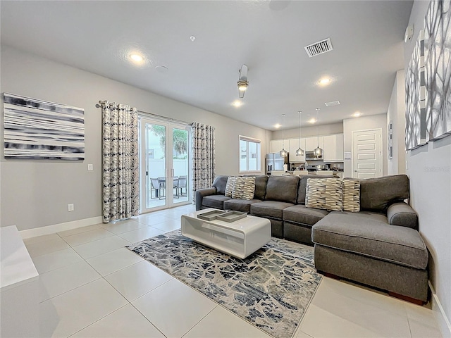 living area with light tile patterned floors, recessed lighting, visible vents, and baseboards