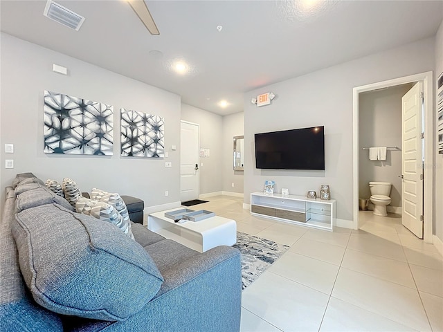 living room with light tile patterned floors, visible vents, and baseboards